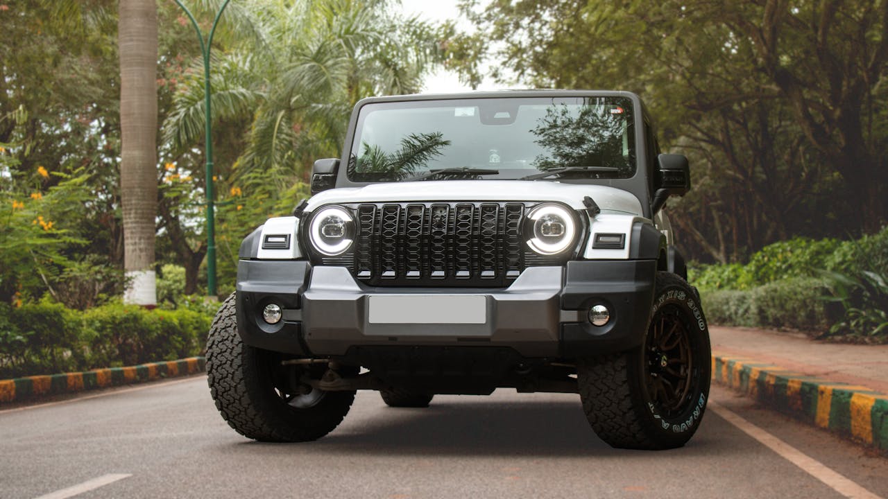 Front view of Mahindra Thar SUV parked on a lush green road in Bengaluru, India.